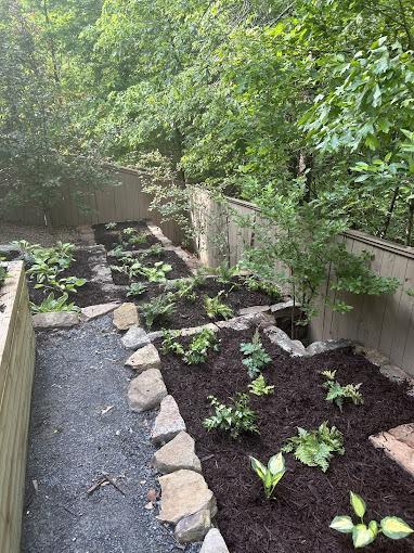 River rock and black mulch combination edging a backyard path